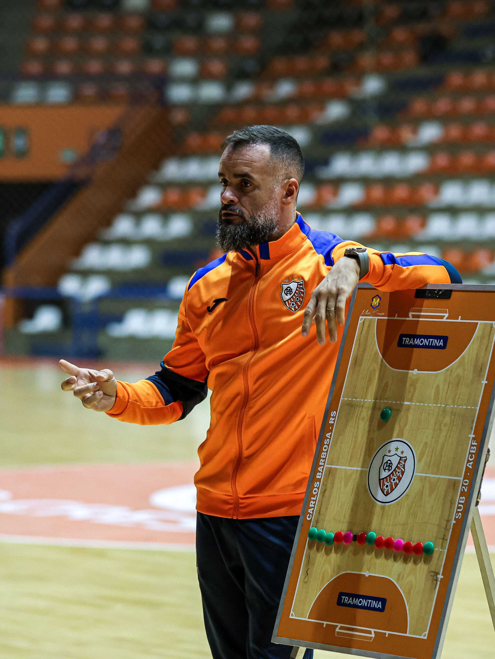 Leonardo Pimentel orientando um treino de futsal com quadro tático.